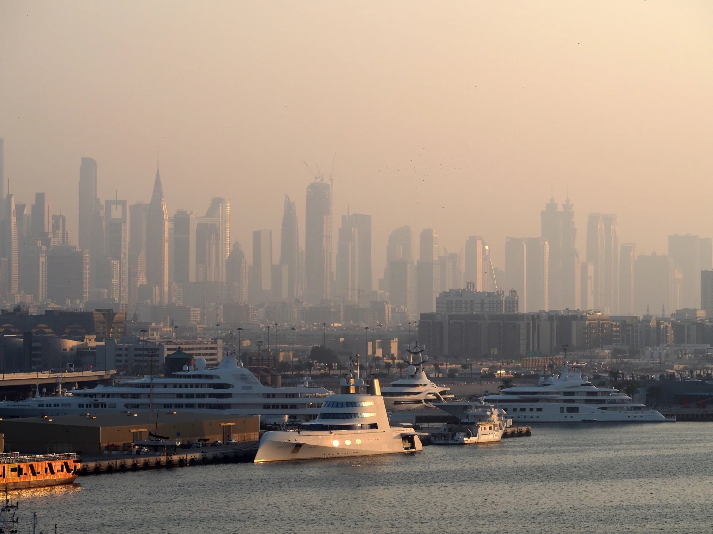 Dubai skyline and marina with private yachts at sunset